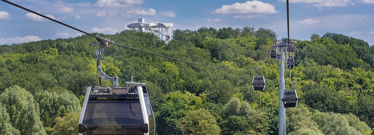 Seilbahnkabinen schweben über die Gärten der Welt hinweg zum Wolkenhain im Kienbergpark